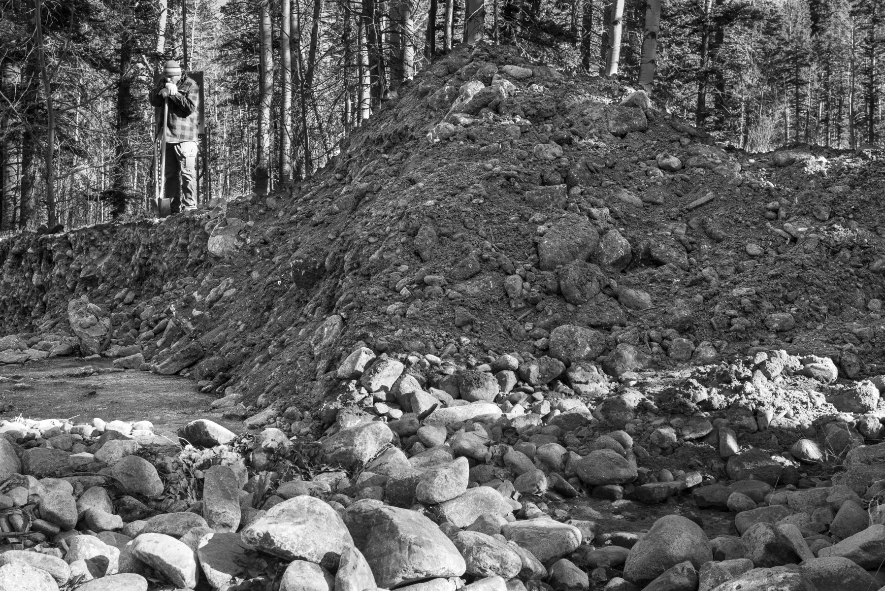 Sanchez assesses the mound of dirt and rock that buried the headgate to the ditch to Holman photo