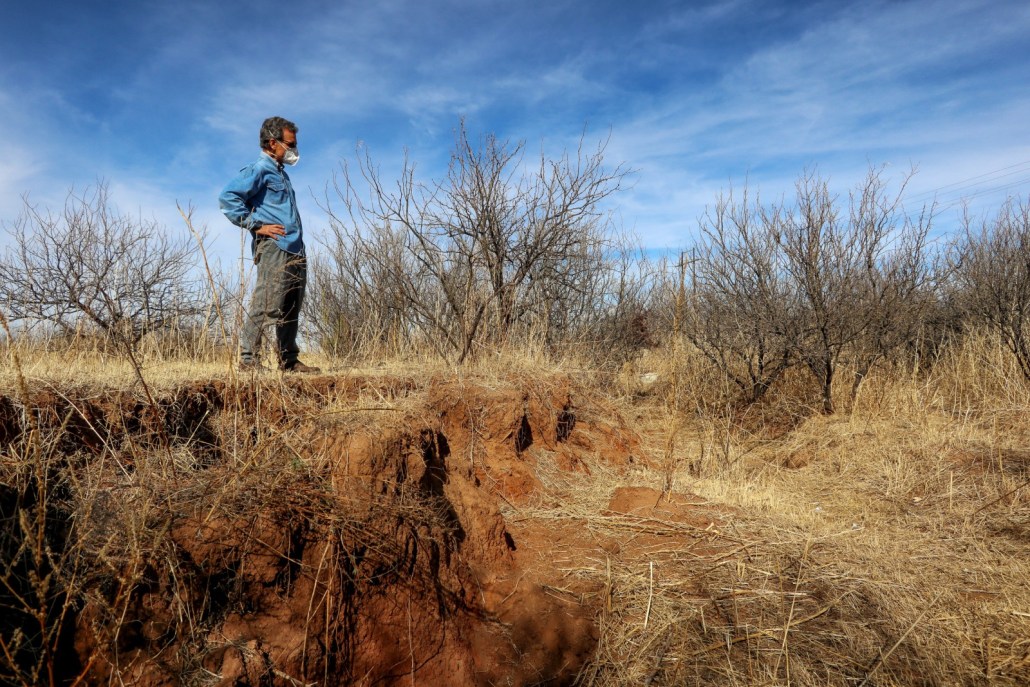 Steve Kiesel surveys a fissure, caused by gr0undwater pumping and land subsidence, that opened close to his home in Cochise County. Photo © Keith Schneider / Circle of Blue